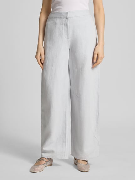 Frauenmodel trägt Wide Leg Pants mit Leinen-Anteil Modell 'SAROKO' von Samsøe Samsøe in hellgrau, ausgestellter Schnitt, Nahaufnahme Oberkörper bis Fuß, Baumwoll-Mix, französische Taschen, glatte Textur, Vorderansicht.