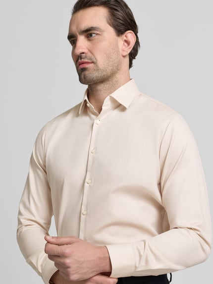 Männermodel trägt Regular Fit Business Hemd aus Baumwolle mit Kentkragen von Jake*s in Beige mit Knopfleiste, Nahaufnahme Oberkörper.