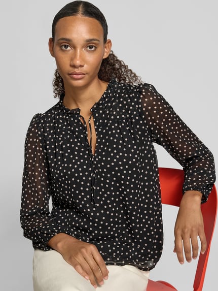 Frauenmodel trägt Regular Fit Langarmbluse mit Bindeverschluss Modell 'DITSY' von ONLY, schwarz mit weißen Punkten, Nahaufnahme Oberkörper, Damen Langarmbluse von ONLY.