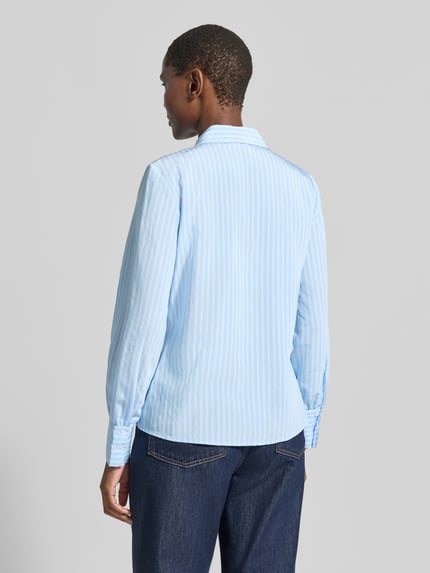 Frauenmodel trägt Regular Fit Hemdbluse aus Viskose-Mix von MORE & MORE in Hellblau mit weißen Streifen, glatte Textur, Ganzkörperansicht Rückansicht.