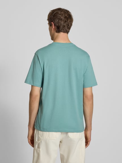 Męski model nosi T-Shirt mit Logo und Rundhalsausschnitt od Jack & Jones, bawełna, krój regular fit, kolor jasnoniebieski, widok całej sylwetki z tyłu, długość tyłu w rozmiarze M: 71 cm