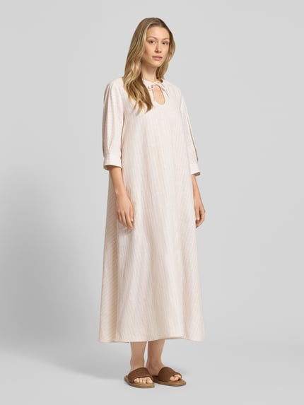Vrouwenmodel draagt Midikleid aus Leinen-Baumwoll-Mix mit 3/4-Arm van MM by Max Mara, wide fit, kleur lichtbeige, model 'MEMO', sleutelgat-hals met strikkoord, ruglengte 126 cm, borstwijdte 50 cm, mouwlengte 40 cm, volledige lichaamsaanzicht van voren.