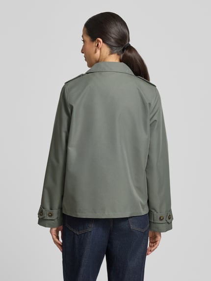 Frauenmodel trägt Jacke mit Reverskragen und Ärmelriegeln Modell 'AMANDA' von Soyaconcept aus Baumwoll-Mix, Regular-Fit, Zweireiher, Rückenlänge bei Größe S 62 cm, Schulterbreite 38 cm, Brustweite 53 cm, Ärmellänge 63 cm, Grünton, glatte Struktur, Ganzkörperansicht Rückansicht.