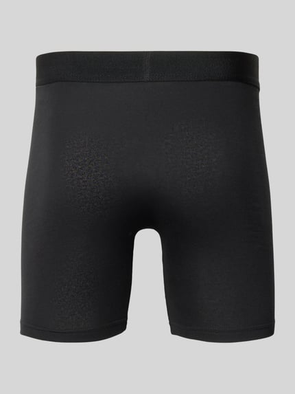 Männermodel trägt schwarze Boxershorts mit elastischem Label-Bund von Snocks, eng anliegend, Ganzkörperansicht Rückansicht.