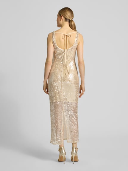 Vrouwenmodel draagt Maxikleid met Pailletten en rückseitiger Schnürung van Little Mistress in goud, nauw aansluitend model, ronde hals, pailletten, vetersluiting aan de achterkant, loopsplit, ruglengte maat 36: 133 cm, borstwijdte maat 36: 44 cm. Ganzkörperansicht rückansicht.