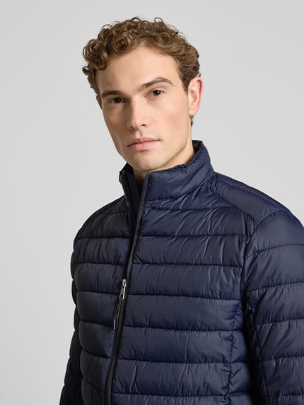 Männermodel trägt Steppjacke mit Reißverschluss von MCNEAL in Dunkelblau, Regular Fit, Stehkragen, Nahaufnahme Oberkörper