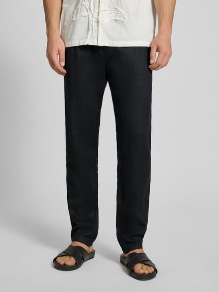 Männermodel trägt Tapered Leinenhose mit Gürtelschlaufen Modell 'OSBY JOGGER' von Marc O'Polo, Unifarben, Material: Leinen, Nahaufnahme Unterkörper, Ganzkörperansicht von vorne.
