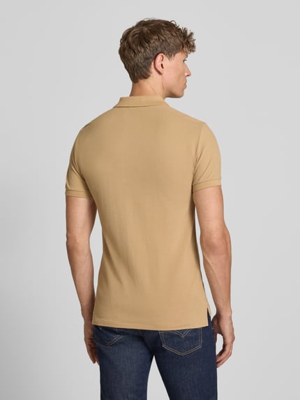 Mężczyzna nosi Slim Fit Poloshirt aus reiner Baumwolle von Polo Ralph Lauren, kolor beżowy, gładka faktura, Ganzkörperansicht Rückansicht.