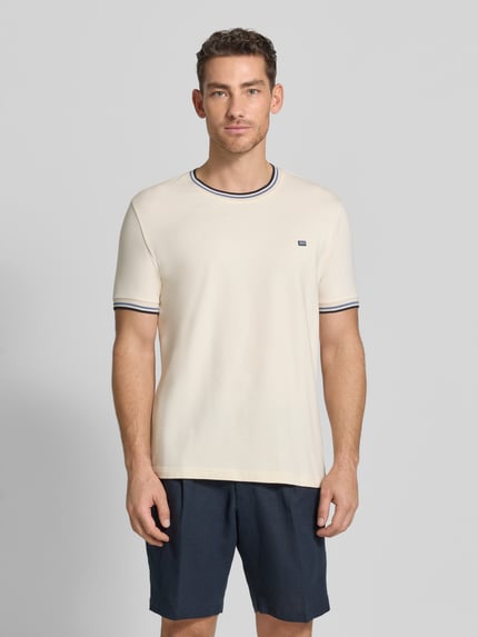 Männermodel trägt T-Shirt mit Kontraststreifen und Rundhalsausschnitt von Christian Berg Men aus Baumwoll-Elasthan-Mix, Regular-Fit, Rückenlänge 71 cm, Ganzkörperansicht von vorne.