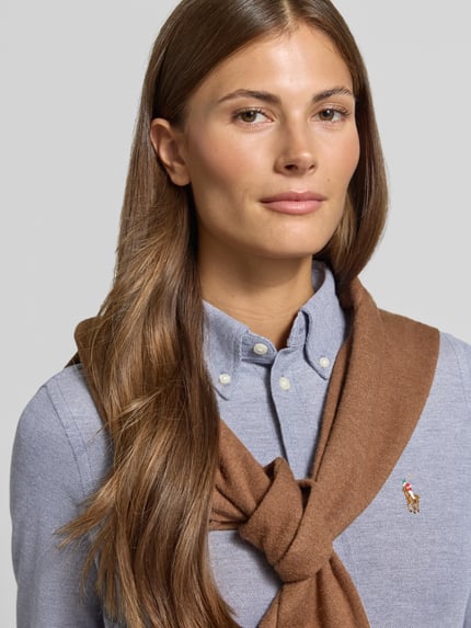 Vrouwenmodel draagt Regular Fit overhemdblouse uit puur katoen van Polo Ralph Lauren, lichtblauw met bruin detail, close-up bovenlichaam.