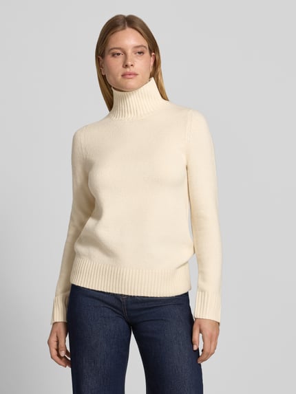 Frauenmodel trägt Rollkragenpullover mit Label-Detail von JAKE*S WOMAN CASUAL in Creme, uni, Strickstruktur, Regular Fit, Langarm; Ganzkörperansicht von vorne.