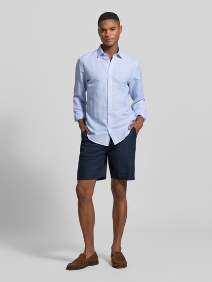 Männermodel trägt Slim Fit Business-Hemd aus leinen-mix van Jake*s, lichtblauw, kentkraag, knoopsluiting, met lange mouwen, ruglengte maat M 69 cm, schouderbreedte 46 cm, mouwlengte 64 cm, ganzlichaamsaanzicht van voren.