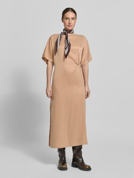 Vrouwenmodel draagt midi-jurk met knoopdetail model 'INDAH' van Drykorn van mix van cupro en katoen, recht model, ronde hals, zijsplit. Ganzkörperansicht von vorne.