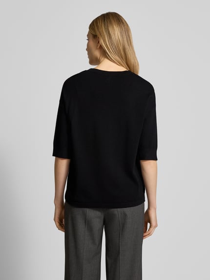 Modelka nosi Regular Fit T-Shirt aus Viskose-Mix Modell 'Morla' od B.Young, czarny kolor, gładka tekstura, krój regular fit, 7/8 rękaw, długość tyłu 57 cm, długość rękawa 23 cm, widok całej sylwetki z tyłu.