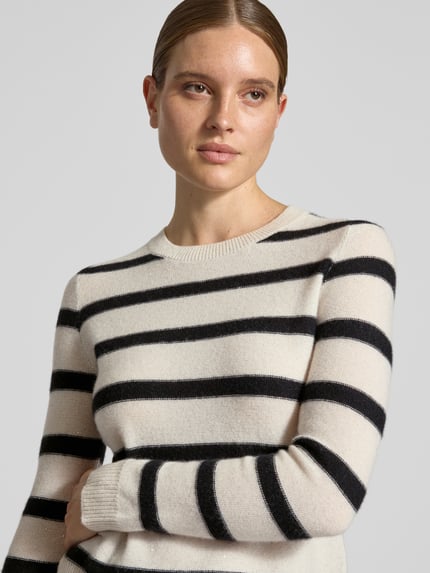 Frauenmodel trägt Strickpullover aus Kaschmir-Mix von Christian Berg Woman in Creme mit schwarzen Streifen, taillierte Passform, Nahaufnahme Oberkörper.