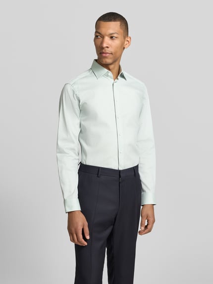 Mężczyzna-model nosi Regular Fit Business-Hemd mit Kentkragen od Christian Berg Men, bawełna, krój regular fit, zapięcie na guziki, sportowe mankiety, zaokrąglony dół, długość pleców w rozmiarze 39/40: 78 cm, szerokość ramion w rozmiarze 39/40: 43 cm, długość rękawa w rozmiarze 39/40: 65 cm, jasny kolor, gładka tekstura, widok całej sylwetki od przodu.