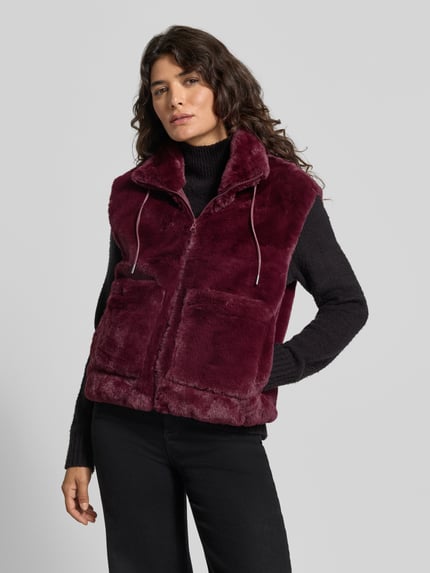 Frauenmodel trägt Weste mit Stehkragen Modell 'FONY' von FREE/QUENT in Bordeaux, sichtbare Eingrifftaschen, gerader Schnitt, Ganzkörperansicht von vorne. Rückenlänge 56 cm, Schulterbreite 45 cm, Brustweite 48 cm.