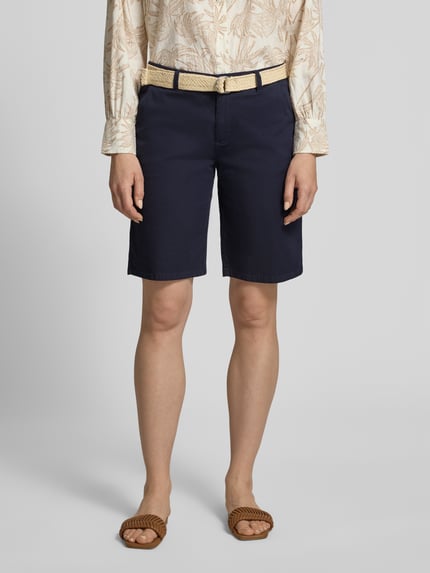 Vrouwenmodel draagt donkerblauwe dames Bermudas met riem van Soyaconcept, mix van katoen en elastaan, regular fit, model 'ROVENA', bandwijdte maat 36: 41 cm, binnenbeenlengte maat 36: 26 cm, voorkant bovenlichaam tot knieën, nahaufnahme onderlichaam.