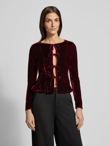 Frauenmodel trägt Bluse aus Samt mit Schürung Modell 'XARANJA' von Mango, taillierter Schnitt, Rundhalsausschnitt, Vorderansicht, Nahaufnahme Oberkörper.