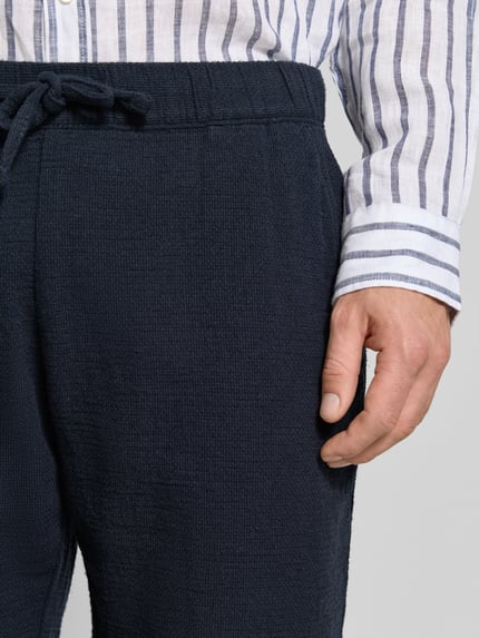 Männermodel trägt Shorts mit elastischem Bund und Tunnelzug von MCNEAL aus Baumwoll-Mix, Regular-Fit, Nahaufnahme Oberkörper.