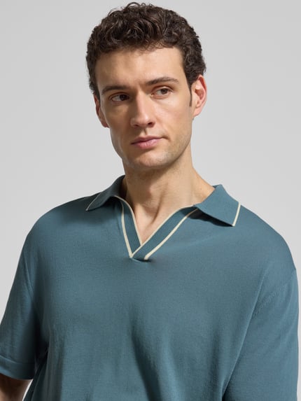 Männermodel trägt Regular Fit Poloshirt aus Baumwolle von CRUNA in Strick-Optik, Farbe Blau, Nahaufnahme Oberkörper.