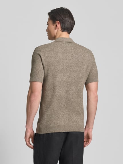 Męski model nosi Regular Fit Poloshirt mit Strukturmuster Modell 'Riley' von Jack & Jones Premium z bawełny, krój regular fit, fakturowany wzór, krótki rękaw, długość tyłu w rozmiarze M: 73 cm, całopostaciowy widok z tyłu.