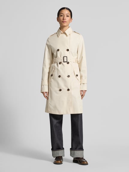 Vrouwenmodel draagt Regular Fit Trenchcoat aus Baumwoll-Mix van s.Oliver RED LABEL, beige kleur, lange mouwen, dubbele knoopsluiting, riemlussen, schouderkleppen, rechte pasvorm, katoenmix twill, zijflapzakken, labelapplicatie, geheellichaamsaanzicht van voren.