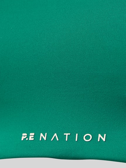 Produktfoto, Slim Fit Sport BH mit Logo-Detail von P.E Nation, grüner elastischer Stoff, weißes Logo, glatte Oberfläche, herausnehmbare Cups
