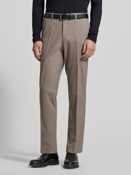 Männermodel trägt Skinny Fit Anzughose aus Woll-Mix Modell 'HESTEN253X' von HUGO, efekt: jednolity kolor, mieszanka wełny, wpuszczane kieszenie, szlufki na pasek, zapięcie na haftkę i zamek błyskawiczny, boczne kieszenie, kieszenie z tyłu, krój skinny fit, model męski, kolor beżowy, całkowity widok z przodu.
