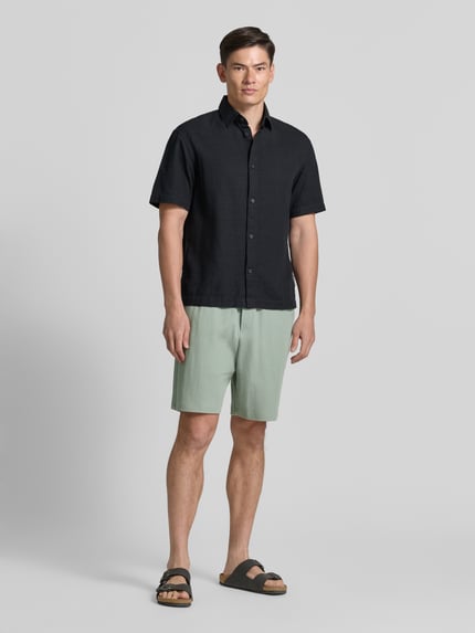 Männermodel trägt Relaxed Fit Sweatshorts aus reiner Baumwolle von Tom Tailor Denim in Optik: Unifarben, Materialverarbeitung: Rippstrick, Mid Waist, seitliche Eingrifftaschen, Gesäßtasche, Bundabschluss: elastisch, Ganzkörperansicht von vorne