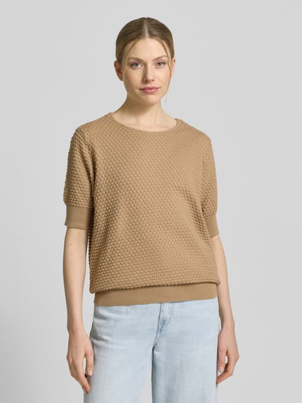 Frauenmodel trägt Strickpullover mit 1/2-Arm Modell 'Dodo' von FREE/QUENT aus reiner Baumwolle mit Strukturmuster, Ganzkörperansicht von vorne.