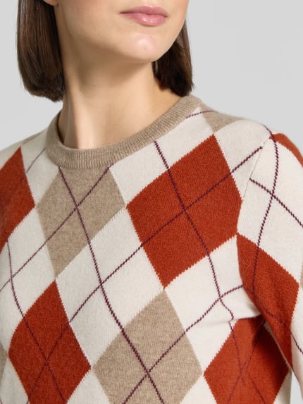 Frauenmodel trägt Regular Fit Pullover aus reinem Kaschmir von Jake*s Casual mit Rautenmuster in Beige, Creme und Rostrot, Nahaufnahme Oberkörper.