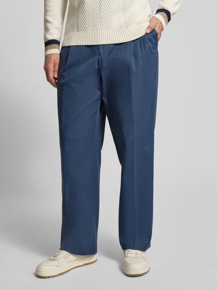 Męski model nosi Weite Hose aus Baumwoll-Mix Modell 'PAT' od BOSS, jednokolorowe, relaxed fit, szerokie nogawki, zakładki w pasie, splot twill, materiał: mieszanka bawełny, zapięcie na haftkę i ukryty zamek, wpuszczane kieszenie boczne, tylne kieszenie, kolor niebieski, tekstura gładka, całkowity widok z przodu.