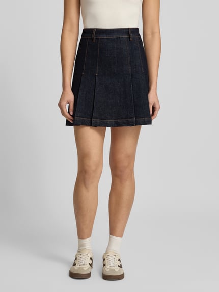 Kobiece modelka nosi jeansową spódnicę mini z efektem melanżu, krój rozkloszowany, szlufki, kontrastowe szwy, denim z mieszanki bawełny, Model 'GERELISE' od HUGO, długość mini, zamek błyskawiczny. Zdjęcie: całkowity widok z przodu.