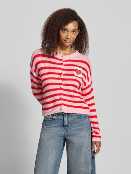 Frauenmodel trägt Strickjacke mit Herzpatch von ONLY, mehrfarbig gestreift, Rundhals, langarm, Knopfleiste, Ganzkörperansicht von vorne.