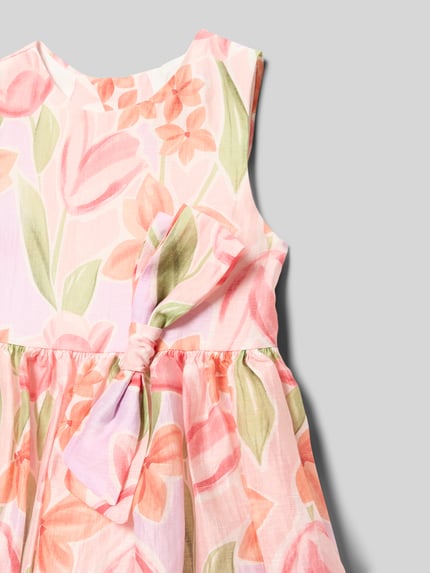 Mädchen trägt Kleid im Allover-Look mit Schleifen-Applikation von Mayoral, Leinen-Mix, florales Muster, Nahaufnahme Oberkörper.