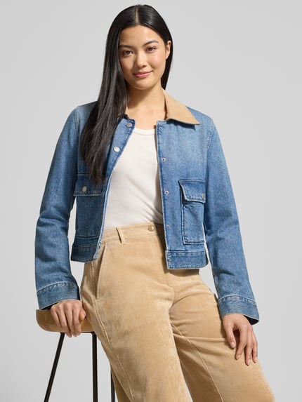 Frauenmodel trägt Regular Fit Cordhose mit Gürtelschlaufen Modell 'C_TACODI' von BOSS Orange, Optik: Unifarben, Materialverarbeitung: Cord, 5-Pocket-Design, Label-Patch, beige Farbe, Nahaufnahme Oberkörper.