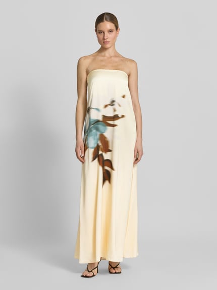 Modelka nosi długa sukienka z wiskozy im Off-Shoulder-Look od Jake*s Cocktail, prosty krój, nadruk z motywem, kremowe tło, długość tyłu w rozmiarze 36: 134 cm, szerokość w rozmiarze 36: 40 cm, widok całej sylwetki z przodu.