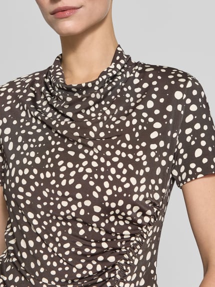 Frauenmodel trägt Slim Fit Kurzarmbluse aus Viskose-Mix Modell 'Endrey' von BOSS, braun mit weißem Punktmuster, Nahaufnahme Oberkörper. Damen Kurzarmbluse von BOSS.