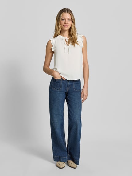 Frauenmodel trägt Regular Fit Blusentop aus reiner Viskose Modell 'ALBA' von Vero Moda, Optik: Unifarben, Rüschenkragen, Rüschen, V-Ausschnitt, Binde-Detail, ohne Ärmel, Material: Viskose, Ganzkörperansicht von vorne.