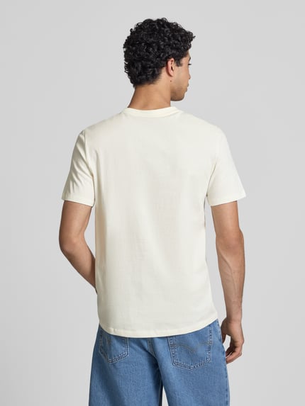 Mężczyzna nosi T-Shirt mit Stitching Modell 'KAAN' od Blend, bawełna, krój regular fit, kremowy kolor, widok całej sylwetki od tyłu.