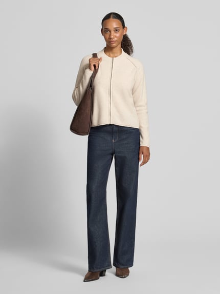 Frauenmodel trägt Regular Fit Jacke aus reiner Wolle von Christian Berg Woman in Beige, kombiniert mit dunkler Hose, Ganzkörperansicht von vorne. Rückenlänge 56 cm, Ärmellänge 62 cm, Stehkragen, Reißverschluss, reine Baumwolle.
