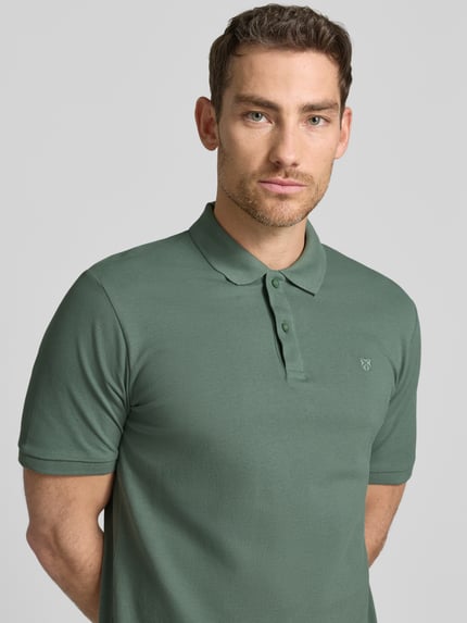 Männermodel trägt Slim Fit Poloshirt mit Stitching von Jack & Jones Premium in Grün, reine Baumwolle, Knopfleiste, Nahaufnahme Oberkörper. Rückenlänge bei Größe M: 70 cm.
