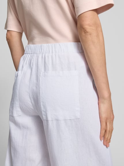 Frauenmodel trägt Stoffhose aus Leinen-Viskose-Mix Modell 'Lava' von FREE/QUENT in Weiß, Relaxed-Fit, sichtbarer Elastikbund, Damen, Nahaufnahme Rückansicht, Bundweite 37 cm, Innenbeinlänge 66 cm Größe S, strukturierte Oberfläche.