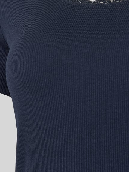 Frauenmodel trägt Pyjama-Oberteil mit Spitzenbesatz von Christian Berg Woman, dunkelblau, Ripp-Optik, Baumwoll-Elasthan-Mix, Nahaufnahme Oberkörper.