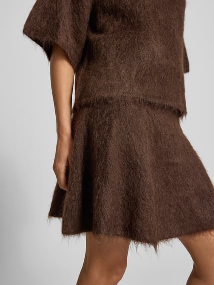 Frauenmodel trägt Strickrock mit elastischem Bund Modell 'TILDE' von YAS, braune A-Linie, Mohair-Mix, Nahaufnahme Oberkörper.