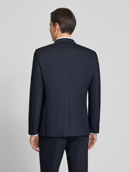Męski model nosi Slim Fit Anzug mit Schurwoll-Anteil Modell 'HUGE' od BOSS, granatowy, drobny wzór, całkowity widok z tyłu.