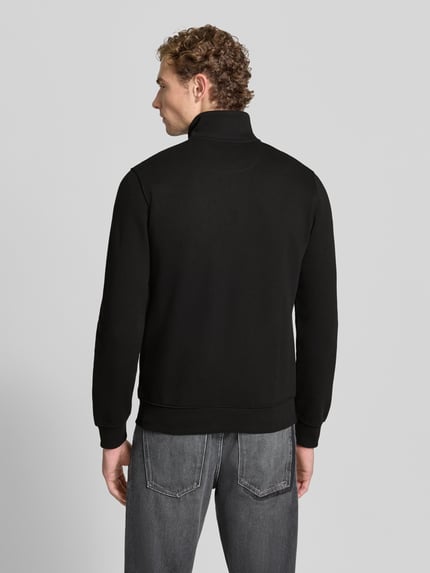 Männermodel trägt schwarze Regular Fit Sweatjacke aus Baumwoll-Mix von s.Oliver RED LABEL, Ganzkörperansicht Rückansicht.
