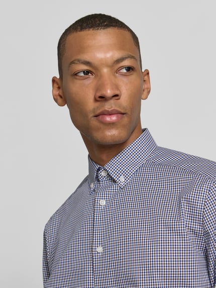 Männermodel trägt Regular Fit Businesshemd mit Button-Down-Kragen von OLYMP, Gitterkaro-Muster, Webware, Nahaufnahme Oberkörper.