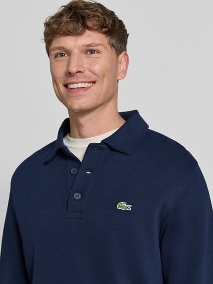 Männermodel trägt Regular Fit Sweatshirt aus reiner Baumwolle von Lacoste in Dunkelblau, dezente Struktur, Nahaufnahme Oberkörper. Herren Sweatshirt von Lacoste.